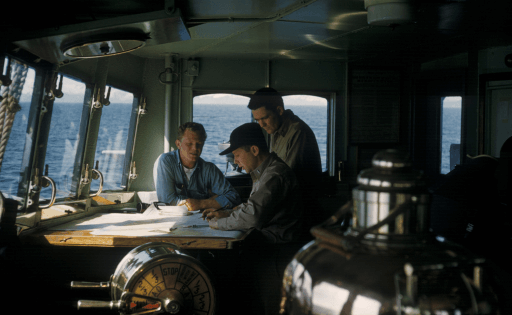 Three men navigating at sea