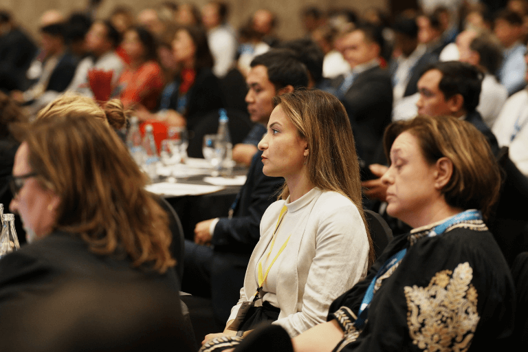 A woman listens intently in the conference