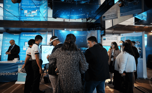 An exhibitor shows a visitor a screen on their stand