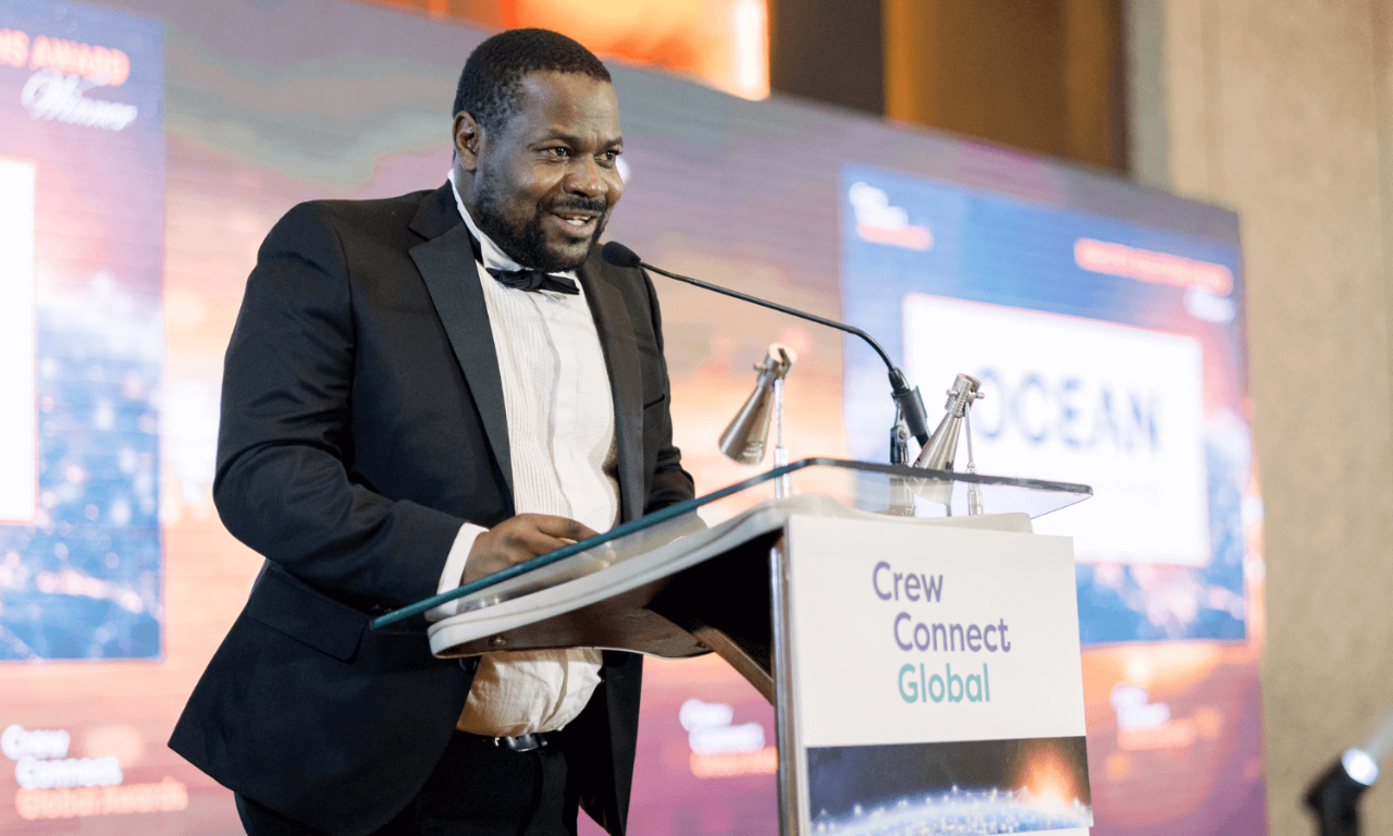 A man in  black tie suit announces a winner at the CrewConnect Global Awards